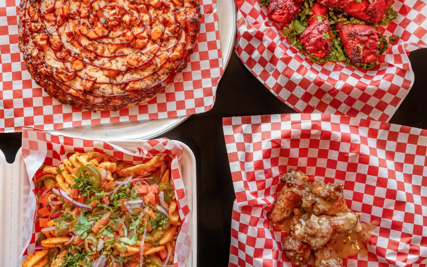 The Mighty Munch spread — curry pizza, tandoori wings and loaded waffle fries